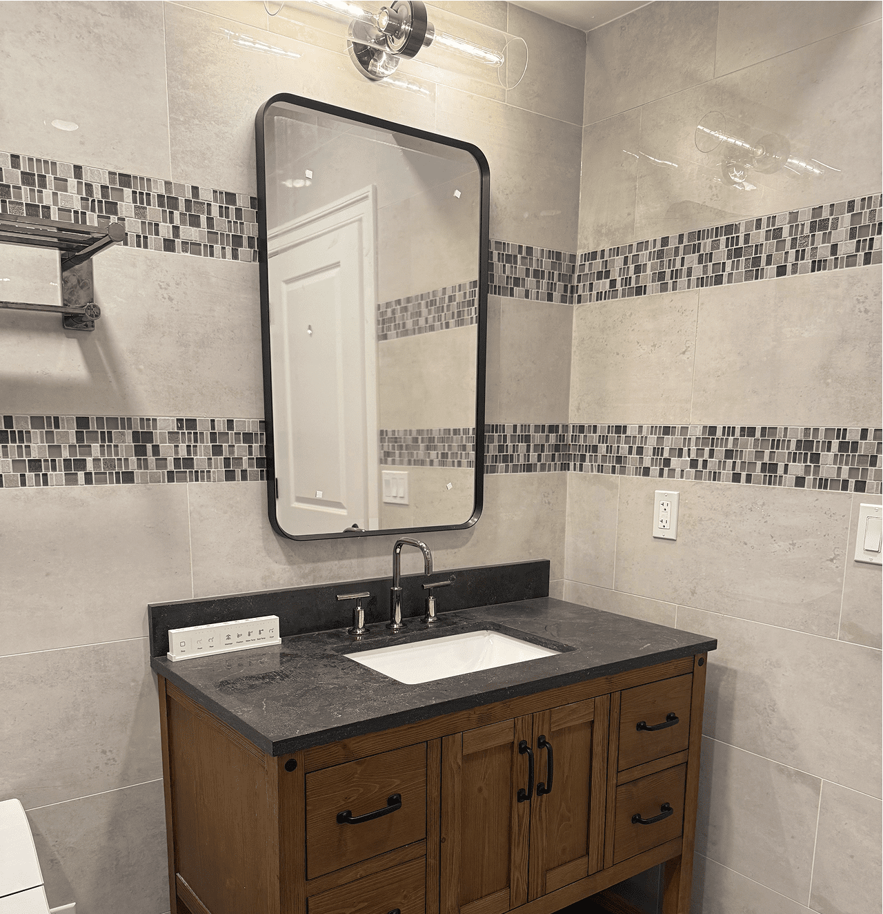 Modern bathroom with wooden vanity and mirror.